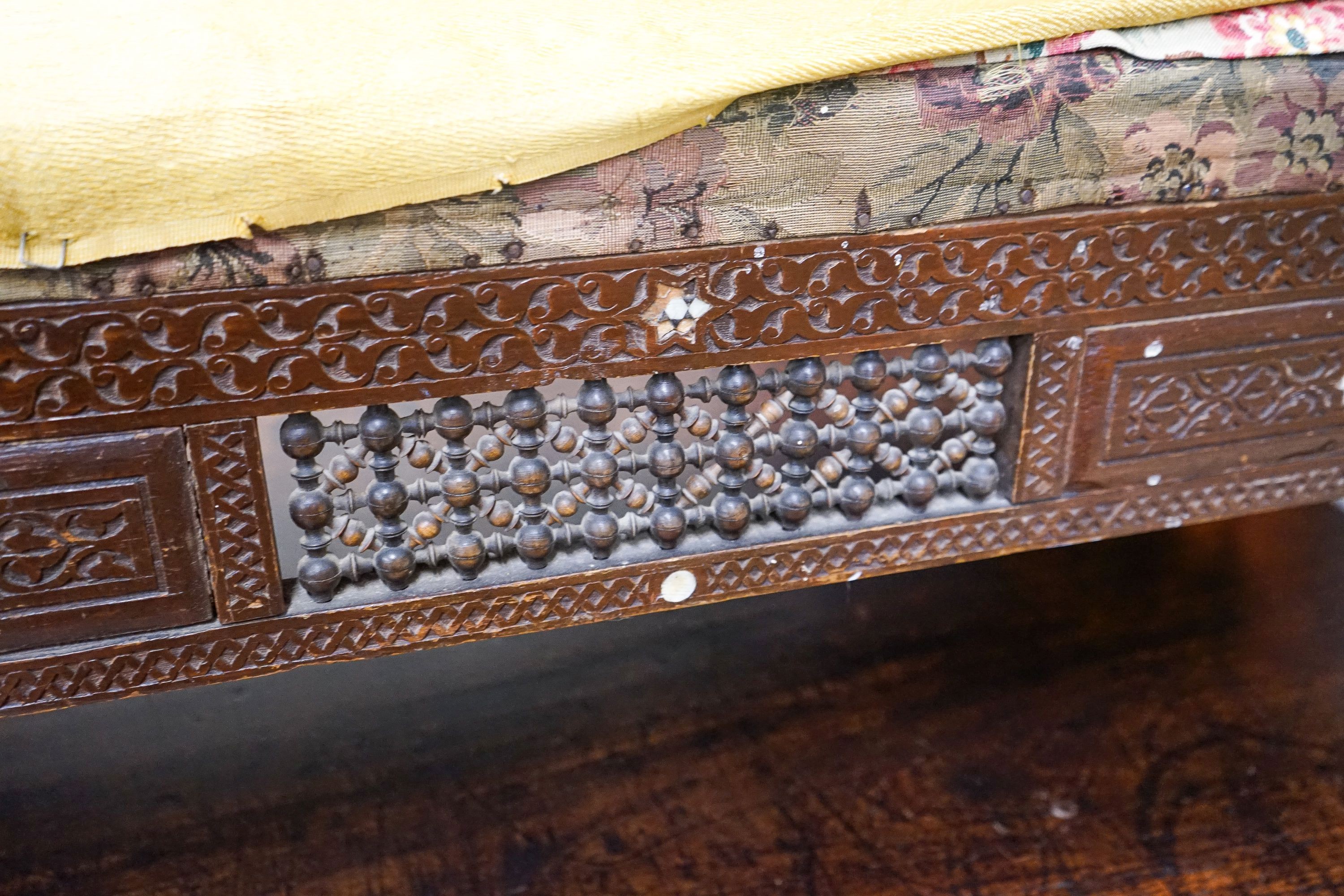 An early 20th century Moorish mother of pearl inlaid carved hardwood window seat, length 134cm, depth 44cm, height 64cm